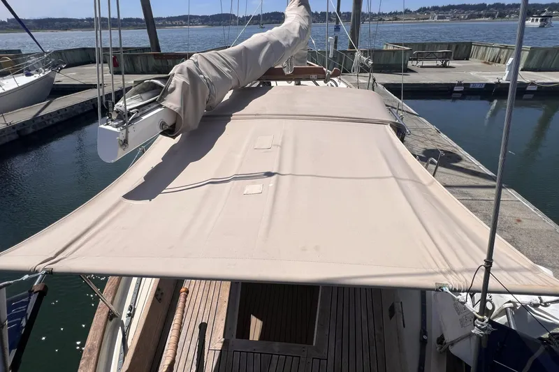 Slide: The Image of 1977 Alajuela 38 MKI sailboat docked, featuring a beige canopy and wooden deck. - 30