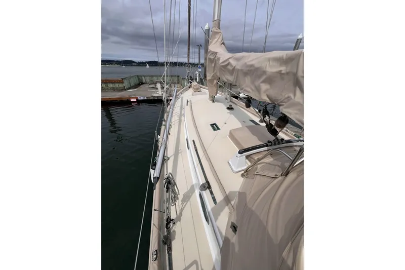 Slide: The Image of 1977 Alajuela 38 MKI sailboat docked, featuring beige deck and covered sails. - 24