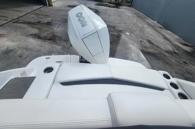Slide: The Image of 2022 Four Winns HD3 boat with Mercury engine, featuring sleek white seating and cup holders. - 5