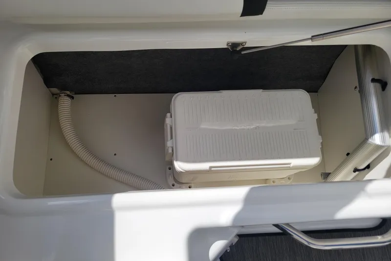 Slide: The Image of Storage compartment in a 2022 Four Winns HD3 boat with a white cooler inside. - 38