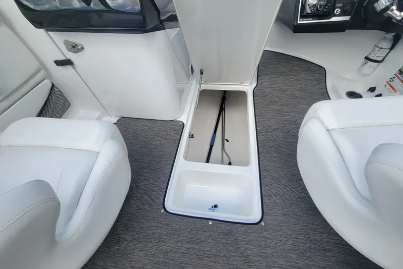Slide: The Image of 2022 Four Winns HD3 boat interior with open storage compartment and white seating. - 25