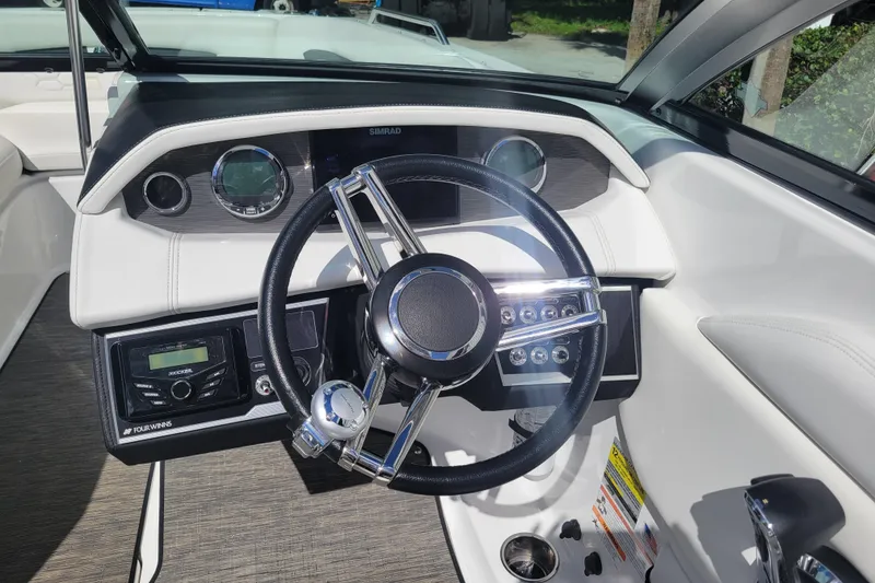 Slide: The Image of 2022 Four Winns HD3 boat dashboard with steering wheel and control panel. - 19
