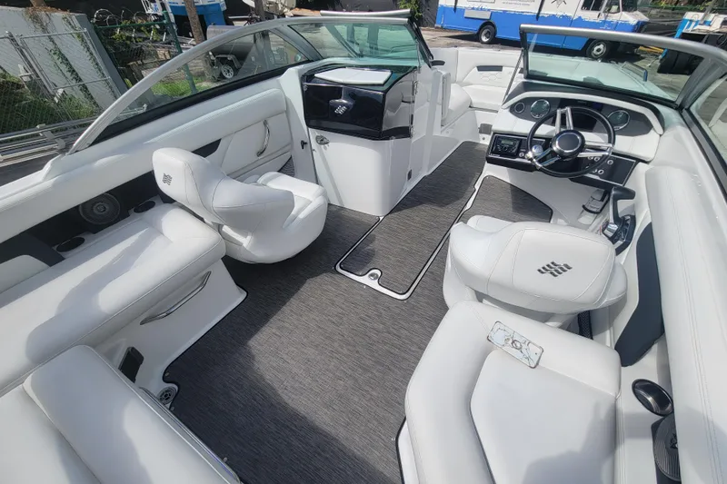 Slide: The Image of 2022 Four Winns HD3 boat interior with white seating and modern dashboard. - 13