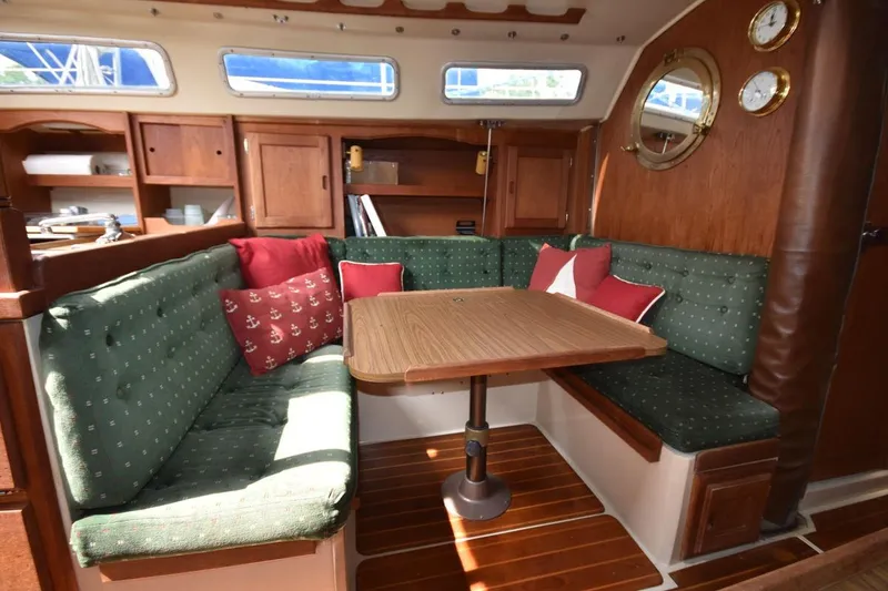 Slide: The Image of Cozy interior of 1984 Catalina 36 MkII sailboat with green cushioned seating and wooden table. - 26