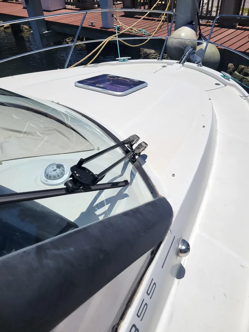 Slide: The Image of 2016 Jeanneau Merry Fisher 855 boat deck with windshield and dock in background. - 15