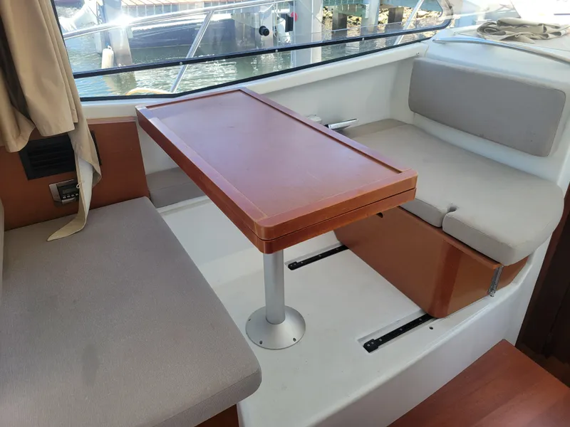 Slide: The Image of Interior of 2016 Jeanneau Merry Fisher 855 with seating and wooden table. - 22