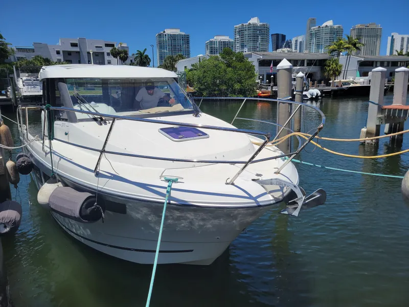 Slide: The Image of 2016 Jeanneau Merry Fisher 855 docked in a marina with city skyline. - 3
