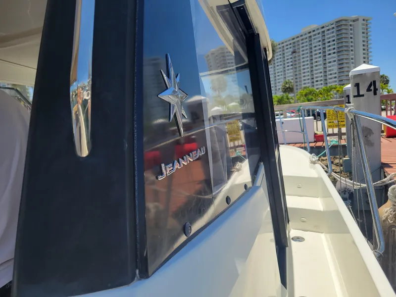 Slide: The Image of 2016 Jeanneau Merry Fisher 855 boat docked, showcasing sleek design and branding. - 4