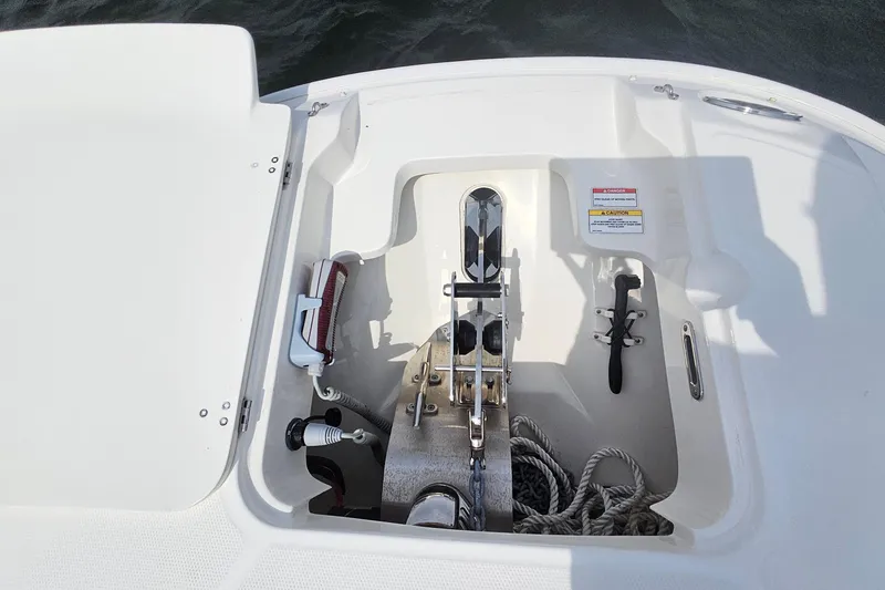 Slide: The Image of Anchor compartment of a 2021 Boston Whaler 270 Dauntless boat, featuring ropes and equipment. - 32