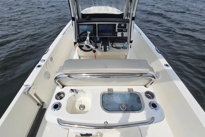 Slide: The Image of 2021 Boston Whaler 270 Dauntless boat interior with helm, seating, and livewell on water. - 21