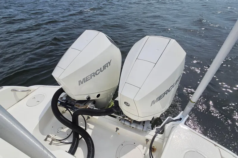 Slide: The Image of Twin Mercury outboard engines on a 2021 Boston Whaler 270 Dauntless boat in water. - 26