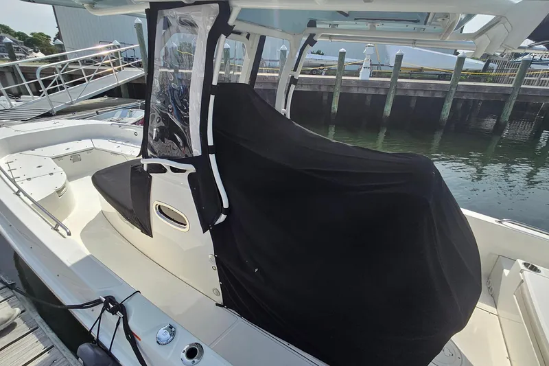 Slide: The Image of 2021 Boston Whaler 270 Dauntless boat docked, featuring covered seating area. - 33
