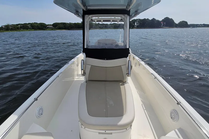 Slide: The Image of 2021 Boston Whaler 270 Dauntless boat on calm water, showcasing seating and helm area. - 13