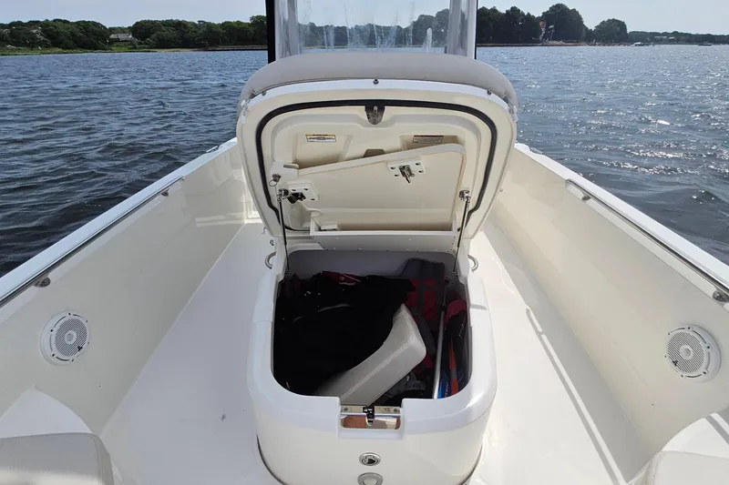 Slide: The Image of 2021 Boston Whaler 270 Dauntless boat with open storage compartment on a calm lake. - 15