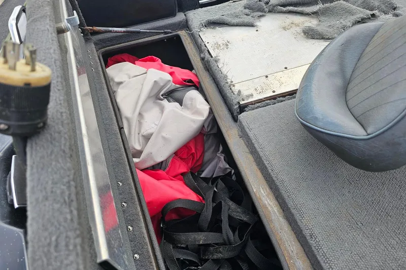 Slide: The Image of Interior of a 1994 Nitro 180 FS boat showing storage compartment with fabric and straps. - 11