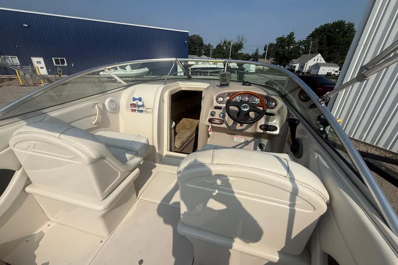 Slide: The Image of 2003 Sea Ray 225 Weekender boat interior with steering wheel and seating. - 14