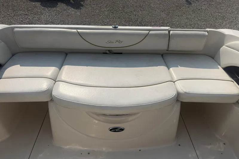 Slide: The Image of 2003 Sea Ray 225 Weekender boat interior with white cushioned seating. - 15
