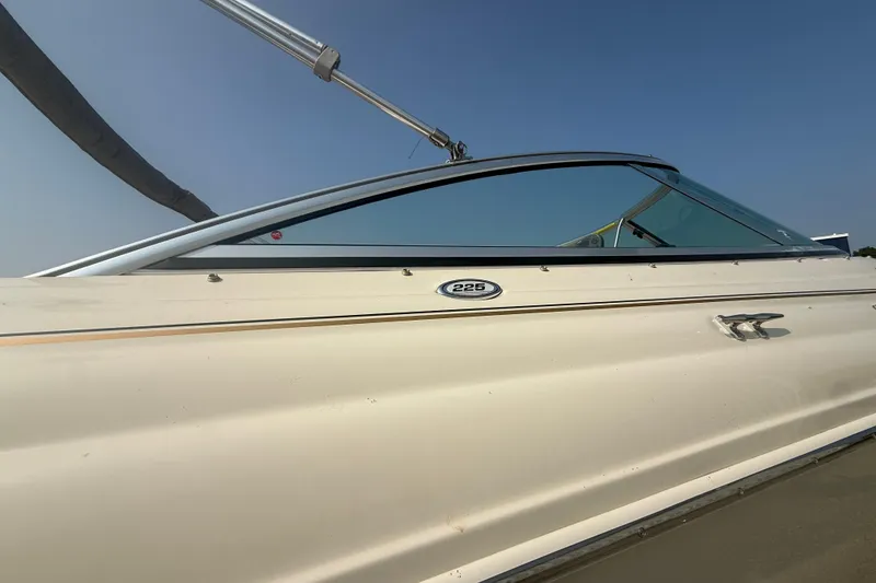 Slide: The Image of 2003 Sea Ray 225 Weekender boat side view under clear blue sky. - 11