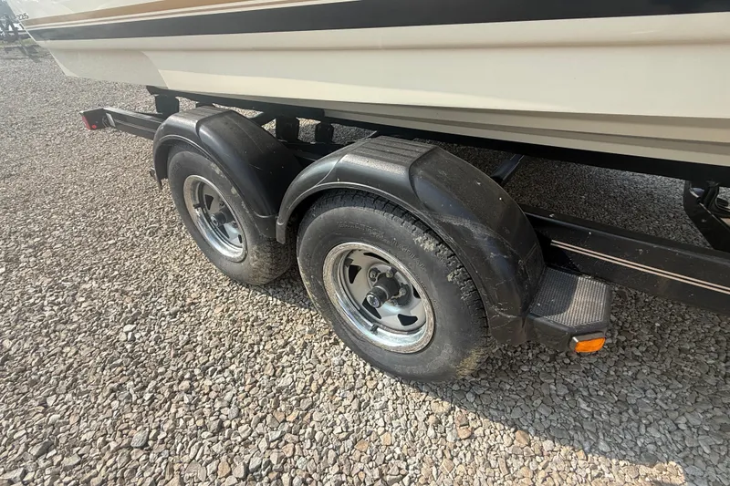 Slide: The Image of Trailer wheels of a 2003 Sea Ray 225 Weekender boat on gravel surface. - 5