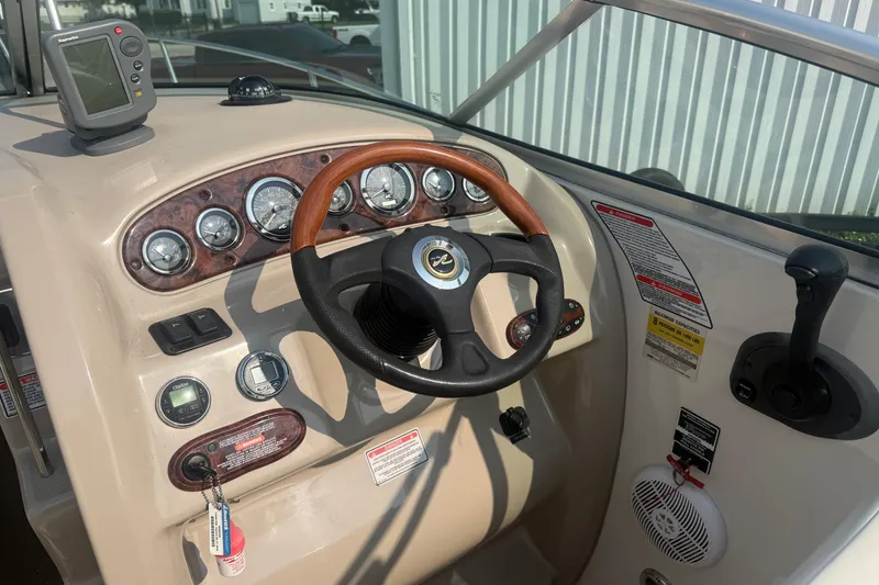 Slide: The Image of 2003 Sea Ray 225 Weekender boat dashboard with steering wheel and navigation instruments. - 20