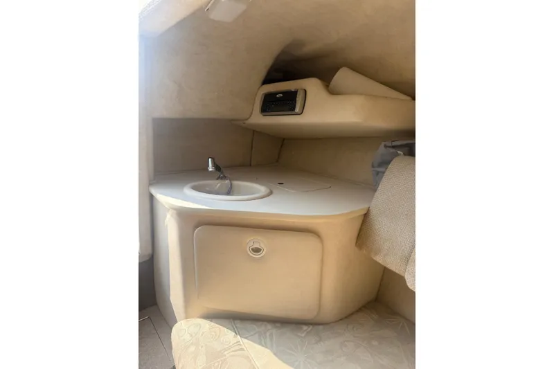 Slide: The Image of 2003 Sea Ray 225 Weekender cabin interior with sink and storage area. - 23