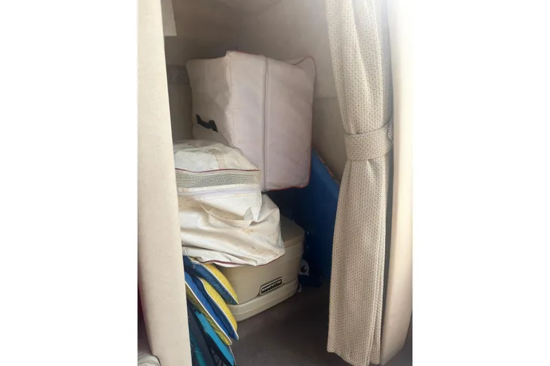 Slide: The Image of Interior storage area of a 2003 Sea Ray 225 Weekender boat with various items. - 24