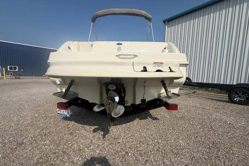 Slide: The Image of 2003 Sea Ray 225 Weekender boat rear view with propeller and trailer. - 10