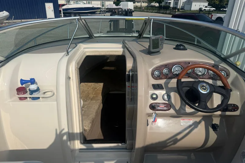 Slide: The Image of 2003 Sea Ray 225 Weekender boat interior with steering wheel and cabin entrance. - 19