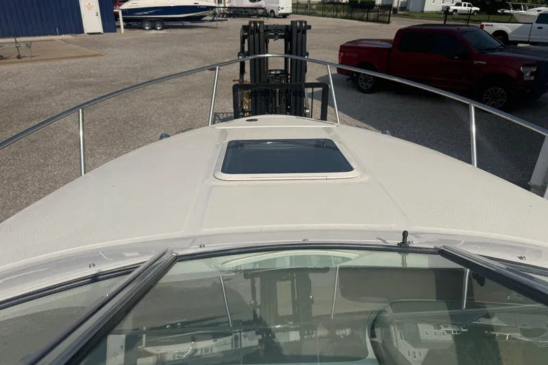 Slide: The Image of 2003 Sea Ray 225 Weekender boat on trailer, viewed from bow, with vehicles in background. - 13