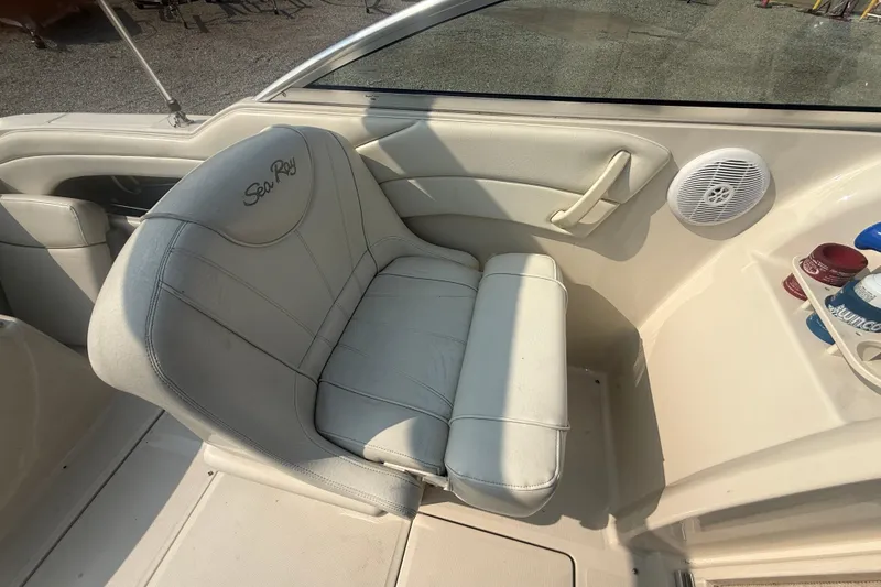Slide: The Image of 2003 Sea Ray 225 Weekender boat interior with white seating and cup holders. - 18