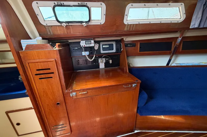 Slide: The Image of Interior of a 1986 Pearson 33 sailboat with navigation station and blue seating. - 2