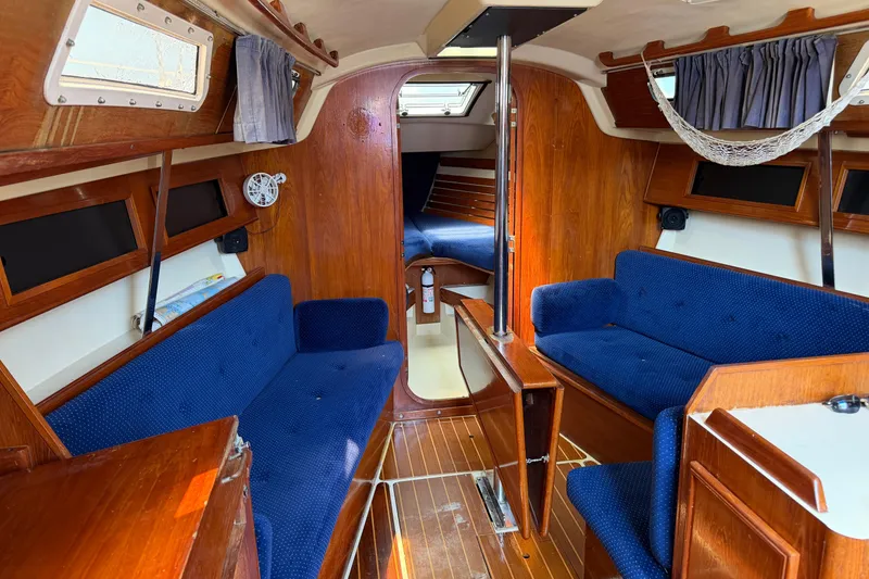 Slide: The Image of Interior of 1986 Pearson 33 sailboat with blue seating and wooden finishes. - 5