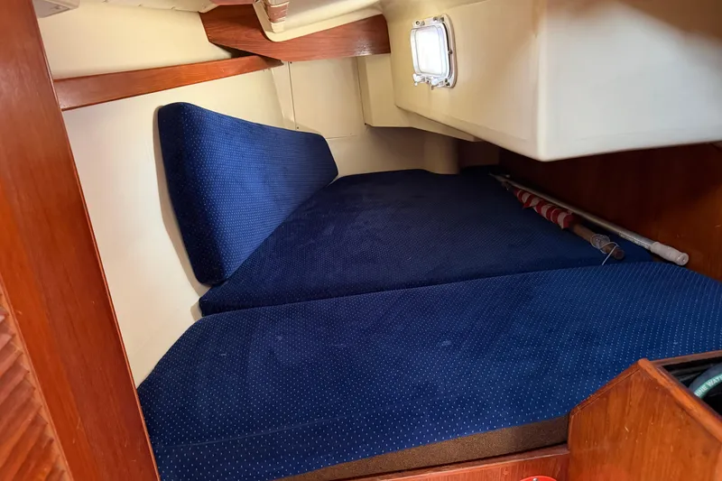 Slide: The Image of Interior cabin of 1986 Pearson 33 sailboat with blue cushions and wooden accents. - 4