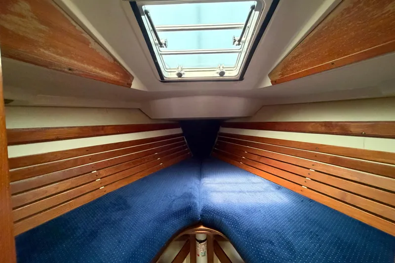 Slide: The Image of Interior cabin of a 1986 Pearson 33 sailboat with wooden paneling and blue upholstery. - 3