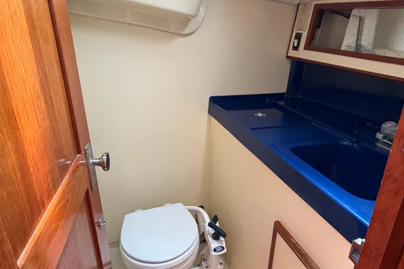 Slide: The Image of 1986 Pearson 33 yacht bathroom with blue sink and compact toilet. - 12