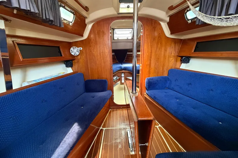 Slide: The Image of Interior of a 1986 Pearson 33 sailboat with blue seating and wooden finishes. - 9