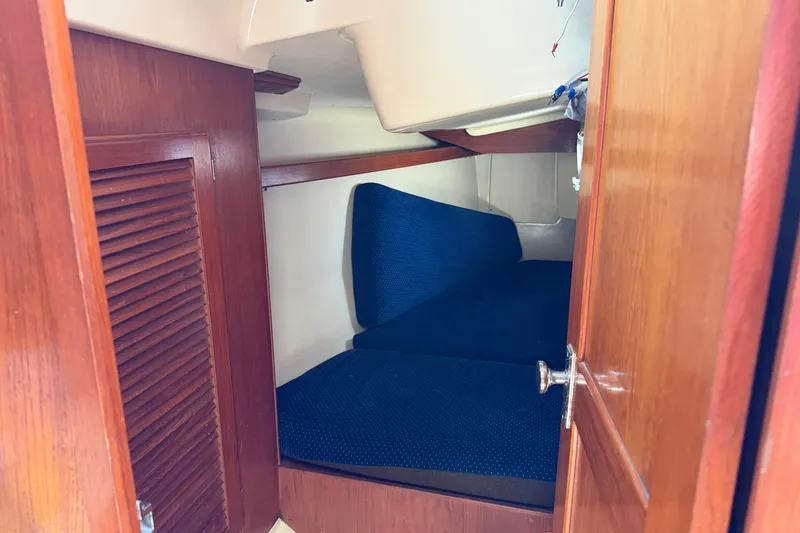 Slide: The Image of Interior cabin of 1986 Pearson 33 sailboat with blue cushions and wooden finish. - 10