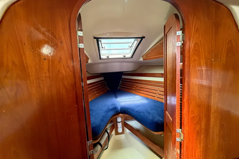 Slide: The Image of Cozy cabin interior of 1986 Pearson 33 sailboat with wooden finish and blue bedding. - 8