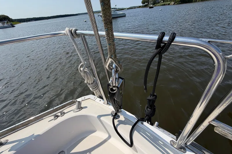 Slide: The Image of Sailboat deck with ropes and railing, Pearson 33, 1986 model, on calm water. - 35