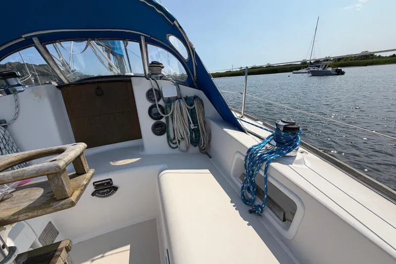 Slide: The Image of 1986 Pearson 33 sailboat cockpit with ropes and winches, docked on a sunny day. - 24