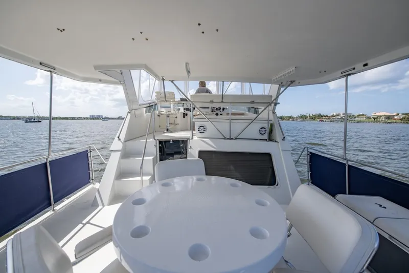 Slide: The Image of 1988 Tollycraft 44 Cockpit Motor Yacht, spacious deck with seating, cruising on calm waters. - 39