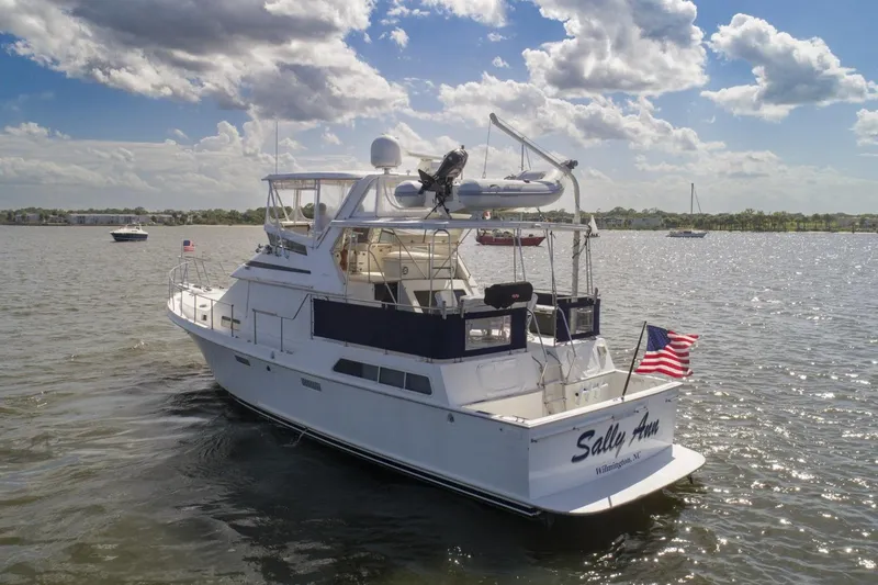 Slide: The Image of 1988 Tollycraft 44 Cockpit Motor Yacht cruising on a sunny day with American flag. - 6
