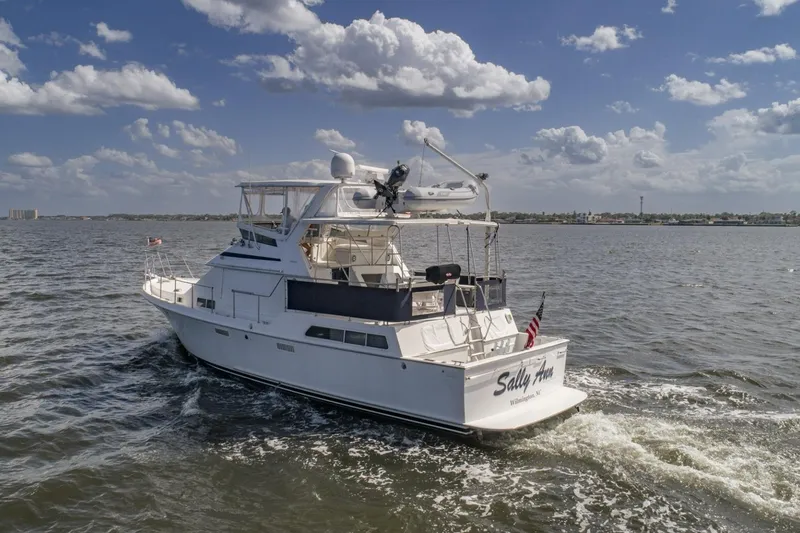 Slide: The Image of 1988 Tollycraft 44 Cockpit Motor Yacht cruising on open water under a partly cloudy sky. - 7