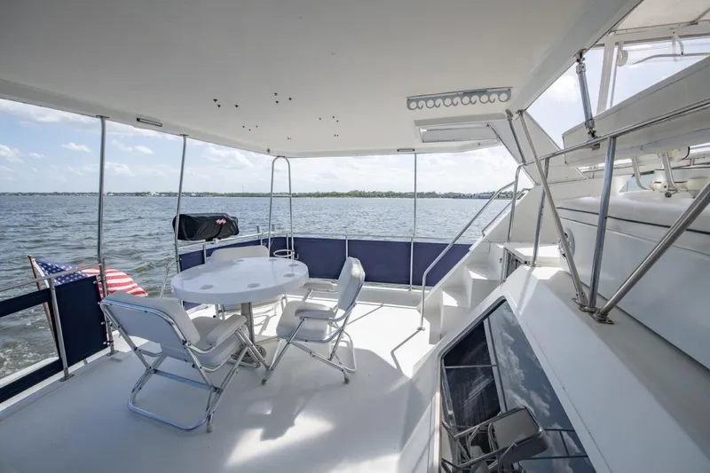 Slide: The Image of 1988 Tollycraft 44 Cockpit Motor Yacht deck with seating, table, and ocean view. - 38