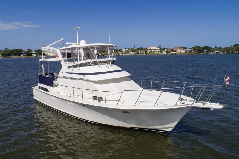 Slide: The Image of 1988 Tollycraft 44 Cockpit Motor Yacht cruising on calm waters under a clear blue sky. - 9