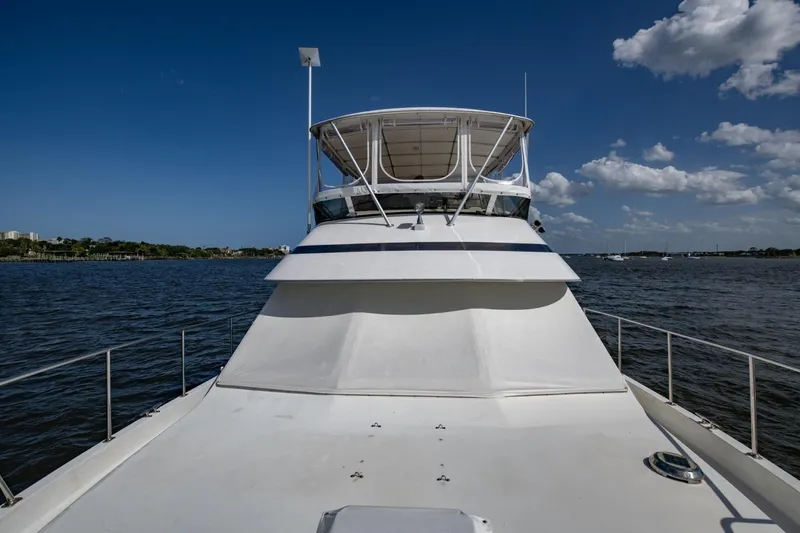 Slide: The Image of 1988 Tollycraft 44 Cockpit Motor Yacht on open water under clear blue sky. - 59