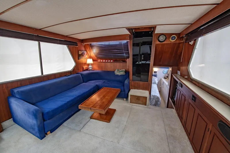 Slide: The Image of Interior of 1988 Tollycraft 44 Cockpit Motor Yacht with blue sofa and wooden accents. - 16