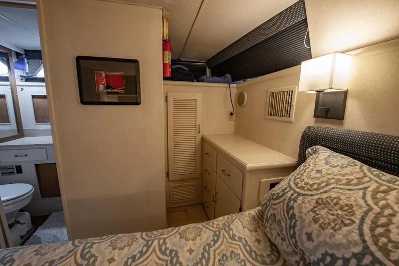 Slide: The Image of 1988 Tollycraft 44 Cockpit Motor Yacht interior with bed, cabinets, and bathroom view. - 29
