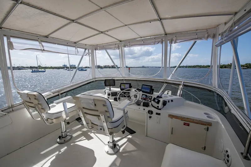 Slide: The Image of 1988 Tollycraft 44 Cockpit Motor Yacht helm with panoramic water views and navigational equipment. - 56