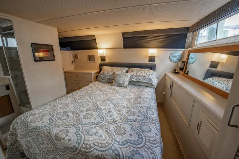 Slide: The Image of Cozy bedroom in 1988 Tollycraft 44 Cockpit Motor Yacht with elegant bedding and ample storage. - 27